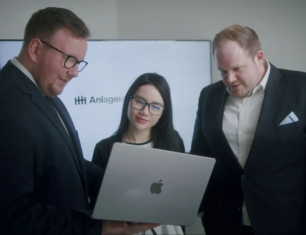 Geschäftsführer Fabian Hafke und Dennis Henke mit Teamassistenz Thu-Giang stehend in einer Besprechung.
